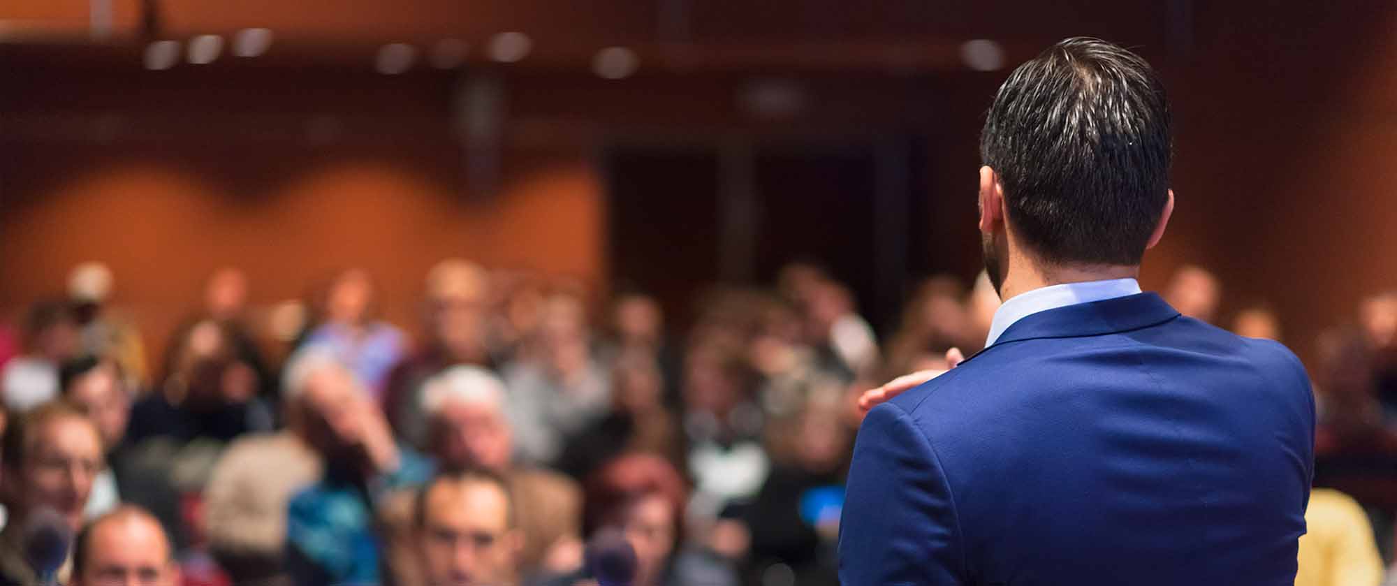 Public speaker giving talk at Business Event.